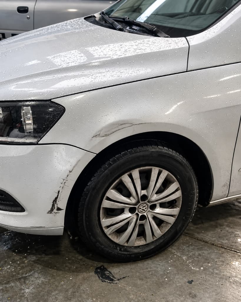 Volkswagen Gol prata com paralama amassado e riscos profundos no para-choque