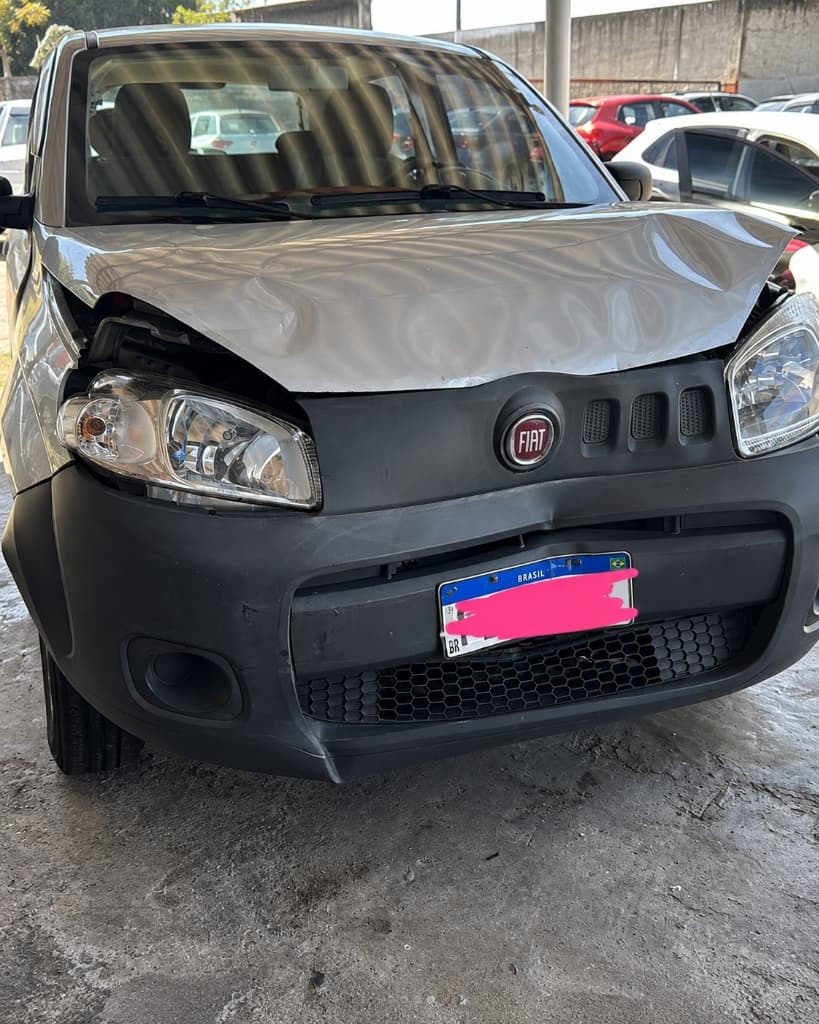 Fiat Uno prata com capô completamente amassado e dobrado após colisão frontal